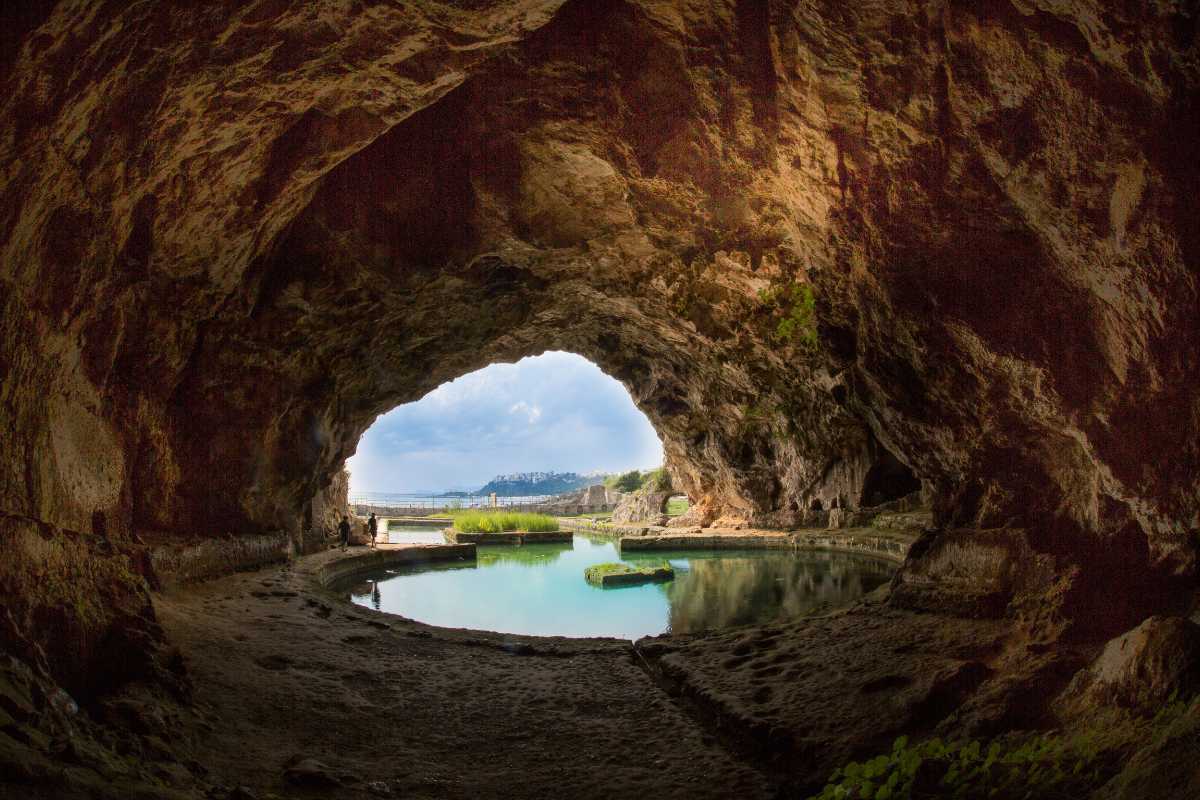 Veduta panoramica di Sperlonga al tramonto, con scorcio sul borgo antico, il mare e la Grotta di Tiberio in primo piano